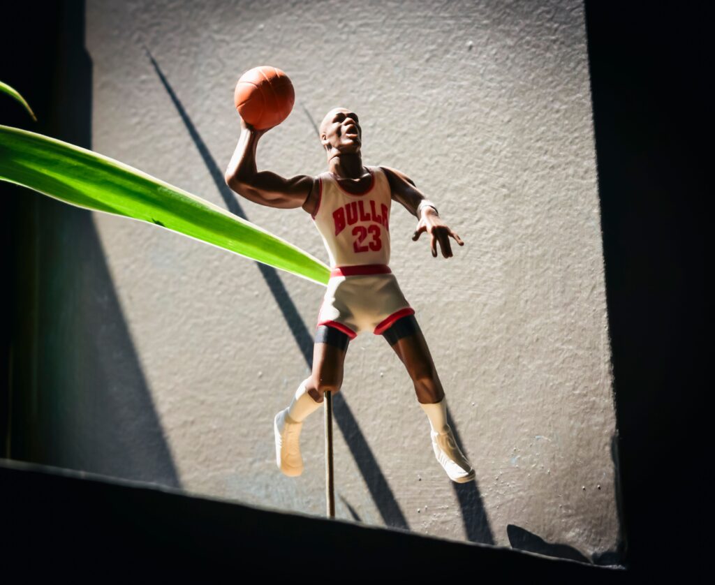 Dynamic figurine of a basketball player in Bulls jersey jumping with a ball in hand. GOAT, jORDAN
